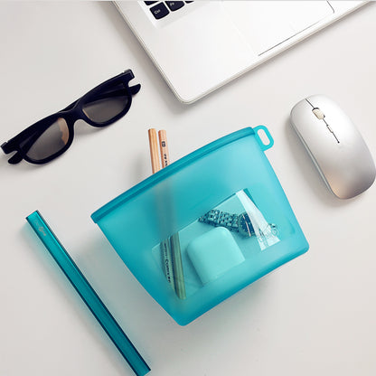 Silicone storage bag on a desk filled with pencils, a watch, and AirPods