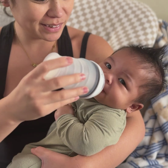 Video of a mom and baby showcasing a collapsible baby bottle